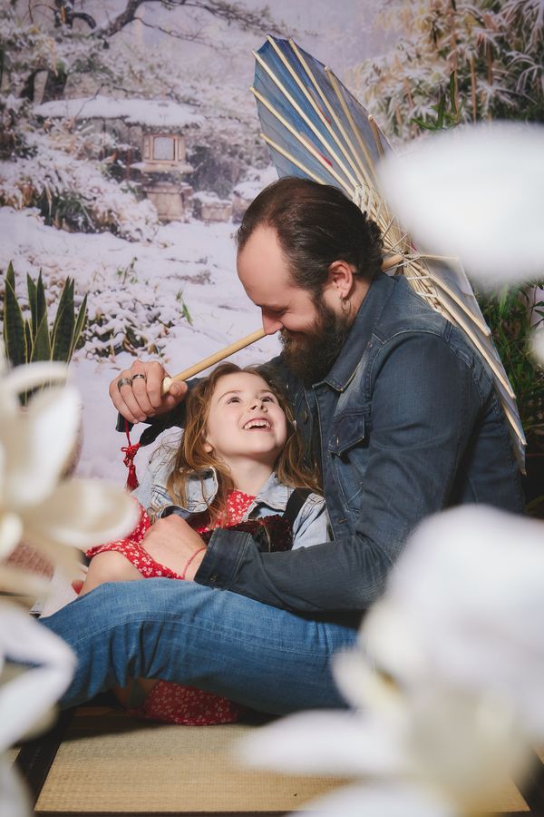 Papa et sa fille qui rient sous une ombrelle, décor japonais enneigé, chez Tape à l'Œil à Hautmont