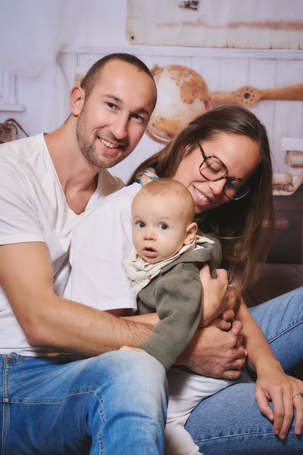 Parents souriants avec leur bébé dans les bras, chez IDKIDS à Englos